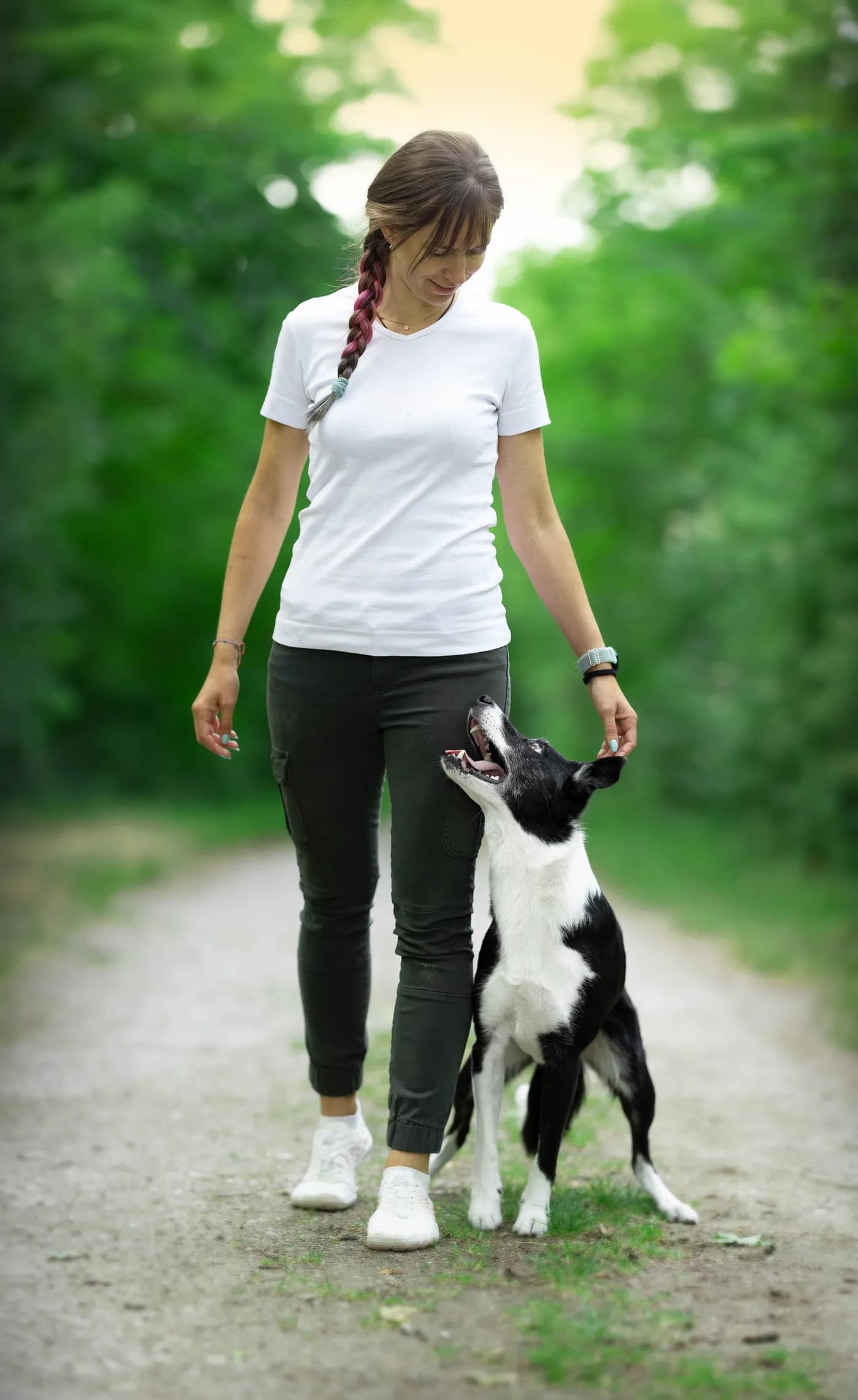 Katharina beim Alltagstraining mit ihrem Border Collie auf einem Waldweg